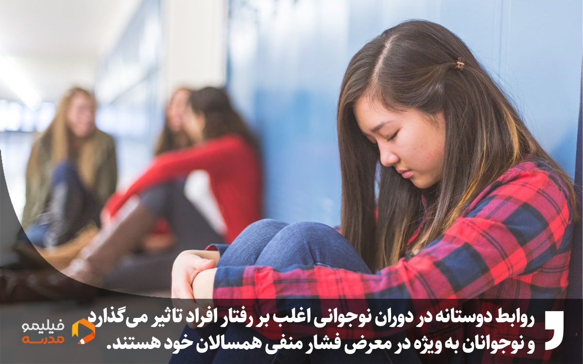 یه دختر که ناراحته و از گروه دوستانش جدا نشسته